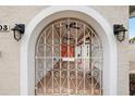 Arched gate detail leading to an inviting porch with an orange double door at 8203 Kirkwood Dr, Tampa, FL 33634