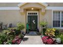 Inviting front entrance with lush landscaping, a welcoming door, and stylish decor, creating a warm and pleasant arrival at 8447 Shallow Creek Ct, New Port Richey, FL 34653