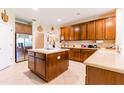 Spacious kitchen featuring an island, tile floors, stainless steel appliances and wooden cabinets at 9313 Lisbon St, Seffner, FL 33584