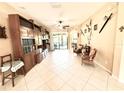 Living room features a built-in bookcase, tile flooring, and comfortable seating near sliding glass doors at 9313 Lisbon St, Seffner, FL 33584