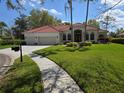 Beautiful single-story home featuring lush green lawn, mature landscaping, and a neutral exterior paint scheme at 9127 Woodridge Run Dr, Tampa, FL 33647