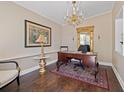 Elegant home office featuring a dark wood desk, ornate chandelier, and a marble topped side table at 1035 58Th N Ave, St Petersburg, FL 33703