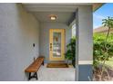 Inviting front porch with a yellow door, bench, and neatly kept landscaping at 11121 Running Pine Dr, Riverview, FL 33569