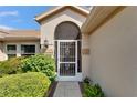 Inviting front entrance with a decorative security door and lush landscaping at 1201 Peridot Ln, Sun City Center, FL 33573