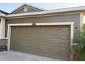 Close up of the two-car garage door of a home with neutral siding and stone accents at 12202 Fairlawn Dr, Riverview, FL 33579