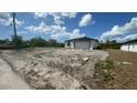 New home featuring a two-car garage in an undeveloped neighborhood under a partially cloudy sky at 12266 Edwards Rd, Port Charlotte, FL 33981