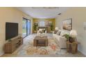 Bright living room with sliding glass door, neutral furniture and a stylish floral rug at 1249 Abbey Crescent Ln, Clearwater, FL 33759