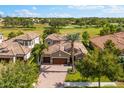 Beautiful home showcasing a tile roof, brick driveway, and lush landscaping with a golf course in the background at 1416 Via Verdi Dr, Palm Harbor, FL 34683