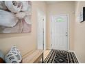 A home entryway featuring neutral walls, patterned rug, and bench with decorative pillows at 26501 Whirlaway Ter, Wesley Chapel, FL 33544