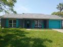 Charming single-story home featuring a colorful exterior and well-maintained front lawn at 3317 Honeymoon Ln, Holiday, FL 34691
