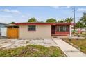 This single-story residence boasts a red trim, security bars on the windows, and a walkway at 3324 W Saint Joseph St, Tampa, FL 33607