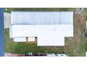 Aerial view of the property showing the roof, deck, and surrounding lawn at 37105 Lois Ave, Zephyrhills, FL 33542