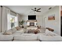 Bright living room with a cozy fireplace, ceiling fan and large window allowing for lots of natural light at 5043 White Chicory Dr, Apollo Beach, FL 33572