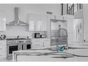 Modern kitchen featuring sleek white cabinets, stainless steel appliances, and a stone waterfall island at 5212 62Nd S Ave, St Petersburg, FL 33715