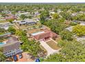 Aerial view of home with pool surrounded by lush greenery and neighborhood, showcasing the property's private backyard oasis at 603 Royal Crest Drive Dr, Brandon, FL 33511