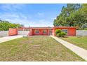 A beautiful coral-colored home featuring an attached garage, and a well-manicured front yard at 603 Royal Crest Dr, Brandon, FL 33511