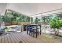 Covered back porch features a wooden deck and a black dining set with chairs at 706 S 56Th St, Tampa, FL 33619