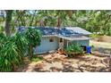 Rear exterior of light blue home, featuring a covered patio, wooden deck, and backyard at 706 S 56Th St, Tampa, FL 33619