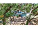 Wooded backyard showcasing the rear exterior of the home through the trees at 706 S 56Th St, Tampa, FL 33619