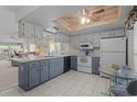 Bright kitchen with white appliances, tile floors and a ceiling fan above the breakfast nook area at 7535 Greystone Dr, Hudson, FL 34667