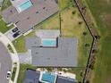 Aerial view showcases a house with a pool, well-maintained yard, and privacy fencing at 8421 Ivy Stark Blvd, Wesley Chapel, FL 33545