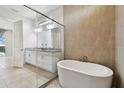 Modern bathroom featuring a soaking tub, walk-in glass shower, and double vanity at 8421 Ivy Stark Blvd, Wesley Chapel, FL 33545