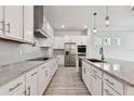 Bright kitchen with stainless steel appliances, granite countertops, and modern white cabinets at 8421 Ivy Stark Blvd, Wesley Chapel, FL 33545