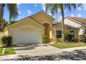 Inviting single-story home with a spacious driveway, attached garage, and lush landscaping at 8820 Cypress Hammock Dr, Tampa, FL 33614