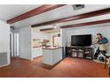 Open concept living room, adjacent to kitchen, with brick floors and decor at 8828 Jasmine Blvd, Port Richey, FL 34668