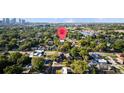 An aerial view of a neighborhood with mature trees and a body of water in the background at 910 W Virginia Ave, Tampa, FL 33603