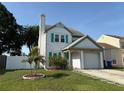 Inviting two-story home with a manicured lawn, small palm tree, and turquoise door and shutters at 10775 Glen Ellen Dr, Tampa, FL 33624