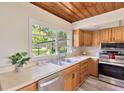 Bright kitchen with stainless appliances, wood cabinets, and a view to the backyard at 1128 S 70Th St, Tampa, FL 33619