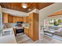 Kitchen with stainless appliances and wood cabinets, opens to the living room with hardwood ceilings at 1128 S 70Th St, Tampa, FL 33619
