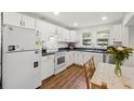 Charming kitchen with white cabinets, laminate countertops and wood grain flooring at 1216 E Lambright St, Tampa, FL 33604