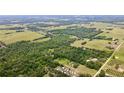 An aerial view highlighting the property's lush forest, open fields, nearby homes, and organized grove at 14409 Curley Rd, Dade City, FL 33525