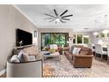 Bright living room featuring a ceiling fan, stylish furniture, and slider leading to outdoor pool at 1570 Marinella Dr, Palm Harbor, FL 34683