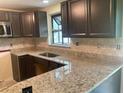 Kitchen featuring granite countertops, dark cabinetry, and stainless steel hardware at 17220 Estes Rd, Lutz, FL 33548