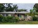 Inviting single-story home surrounded by lush landscaping and vibrant flowering plants at 1735 Cleveland St, Clearwater, FL 33755