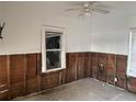 A bedroom with damaged walls and a ceiling fan, showing a room that needs extensive renovation at 2011 Oakwood Ave, Tampa, FL 33605
