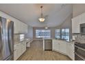 Bright kitchen with stainless steel appliances, white cabinets, and views of the pool at 2252 New Bedford Dr, Sun City Center, FL 33573