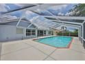 Screened-in pool with a brick trim and view of the backyard and bright sky at 2252 New Bedford Dr, Sun City Center, FL 33573