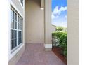 Covered entryway featuring brick pavers, white trim, and views of manicured landscaping at 23325 Abercorn Ln, Land O Lakes, FL 34639