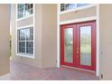 Elegant double front doors with glass panels, complemented by sidelight windows and red brick pavers at 23325 Abercorn Ln, Land O Lakes, FL 34639