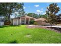 Well maintained single-story home featuring green grass, mature landscaping, and a charming facade at 2903 Manor Ridge Pl, Valrico, FL 33596