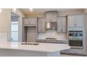 Modern kitchen featuring white quartz countertops, stainless steel appliances, and gray cabinetry at 3206 Lumber Falls Dr, Plant City, FL 33565