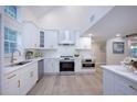 Bright kitchen features white cabinets, stainless steel appliances, and light wood floors at 35 Deerpath Dr, Oldsmar, FL 34677