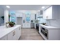 Bright, white kitchen featuring stainless steel appliances and modern marble countertops at 35 Deerpath Dr, Oldsmar, FL 34677