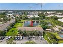 Aerial shot of townhome featuring mature trees, a pond with a fountain, and ample parking at 4734 67Th N Ave, Pinellas Park, FL 33781