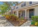 A view of the townhome exterior showcasing landscaping and a cozy seating area at the front entrance at 4734 67Th N Ave, Pinellas Park, FL 33781