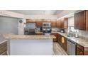 Well-lit kitchen features stainless steel appliances, granite countertops, and wood flooring at 6118 Becklin Pl, Riverview, FL 33578
